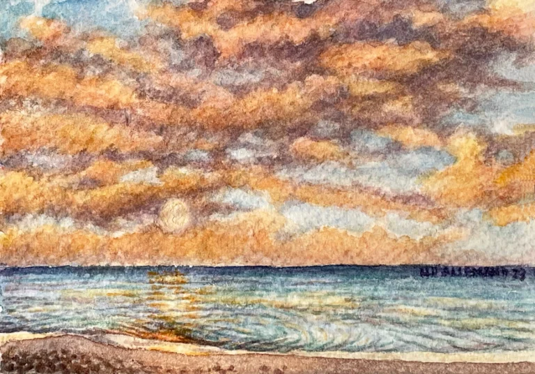 Atardece, oleaje suave con sol entre las nubes